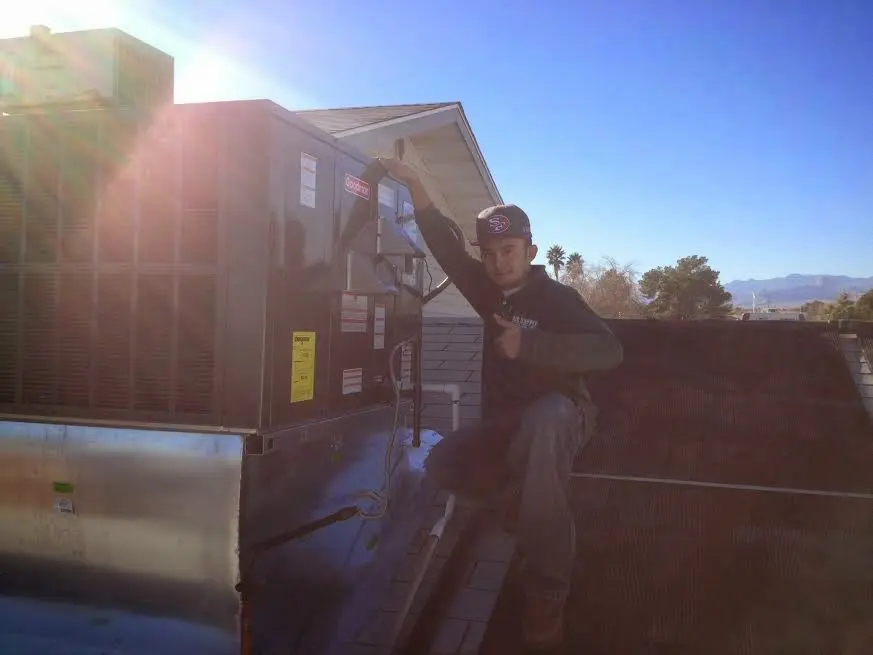 HVAC technician performing Boiler Repair on a rooftop unit in Bellair-Meadowbrook Terrace